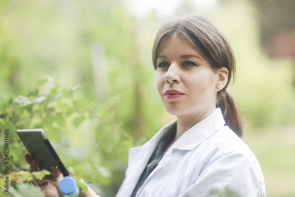 Junge Wissenschaftlertin mit Tablet im Freien