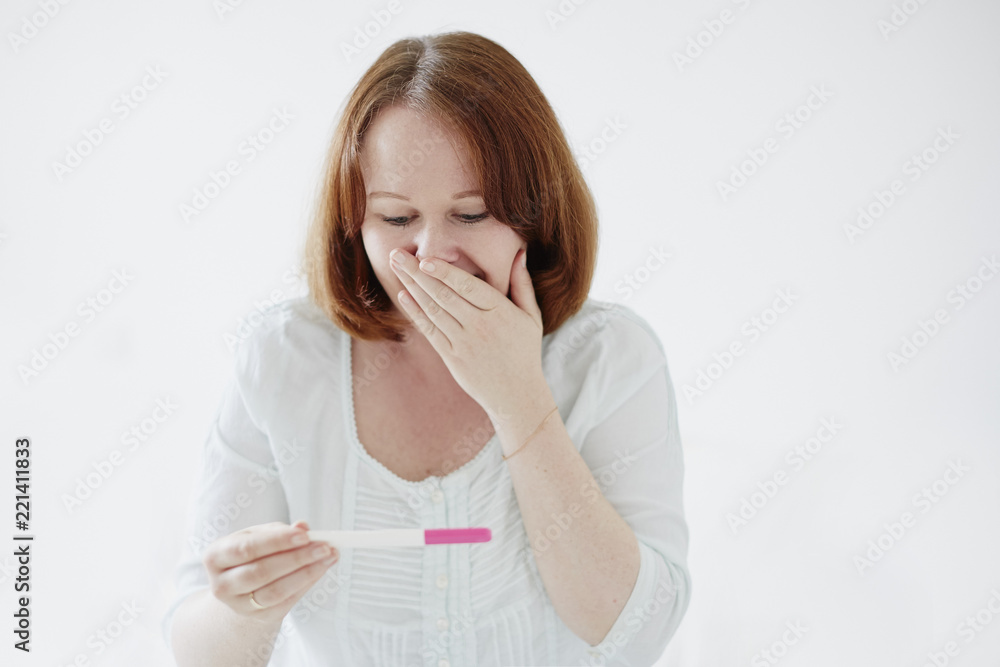 Happy young woman looking at positive pregnancy test Happy young woman looking at positive pregnancy test