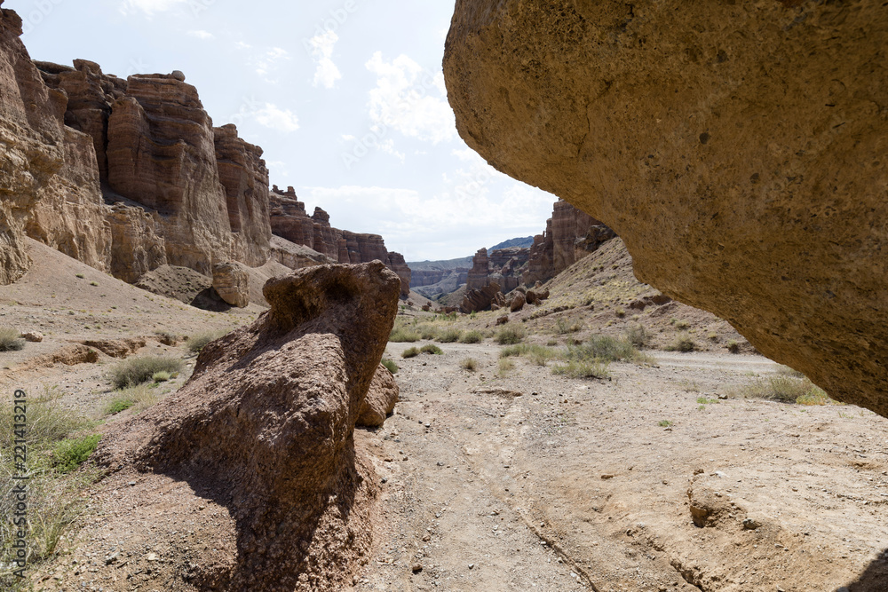 Views within the Charyn Canyon to the reddish sandstone cliffs. The canyon is also called valley of castles and is located east of Almaty in Kazakhstan. Views within the Charyn Canyon to the reddish sandstone cliffs. The canyon is also called valley of castles and is located east of Almaty in Kazakhstan.