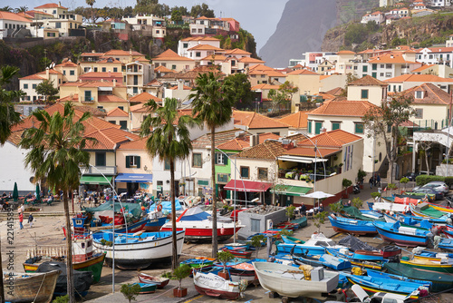 View of C  mara de Lobos in Madeira with Cape Gir  o on the background and boats at the marina