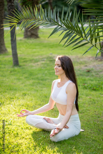 фотографія Cool attractive yogi woman practicing yoga concept, sitting in Lotus exercise on