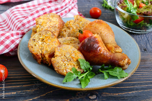 Tasty stuffed chicken legs with salad of fresh vegetables on a wooden background. Top view. Rolls with chicken and vegetables
