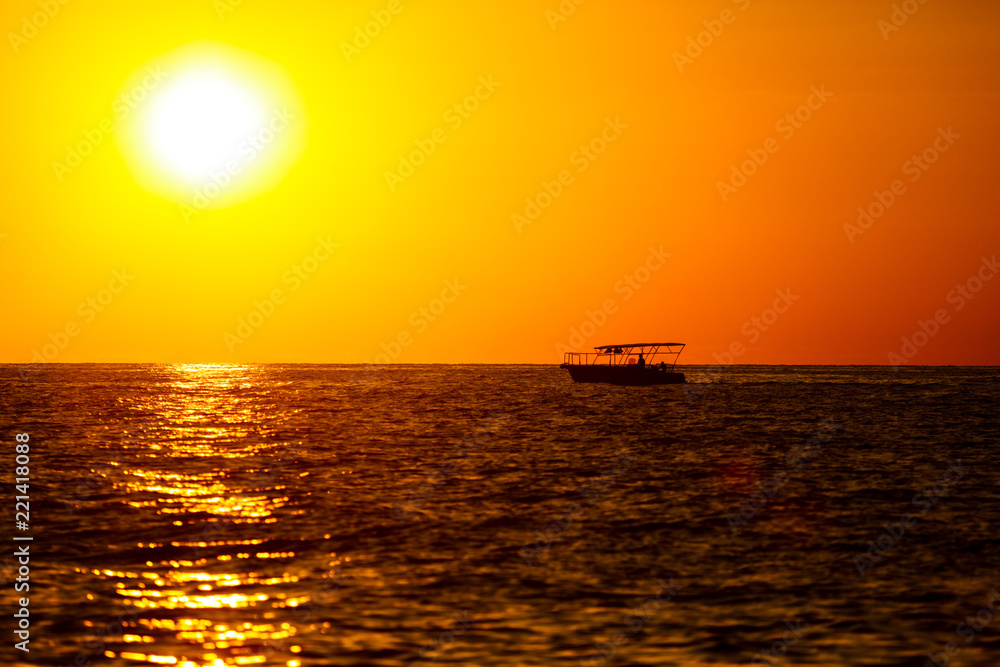 Boat on the sea in the rays of sunset