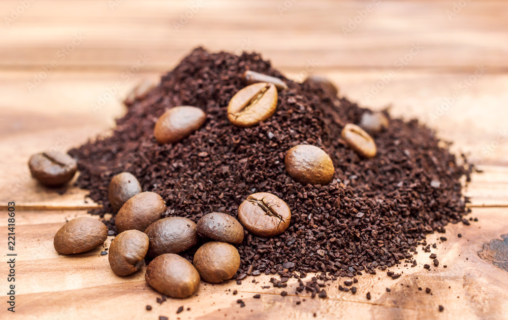 Heap of ground coffee and coffee beans on wooden table. Heap of ground coffee and coffee beans on wooden table.