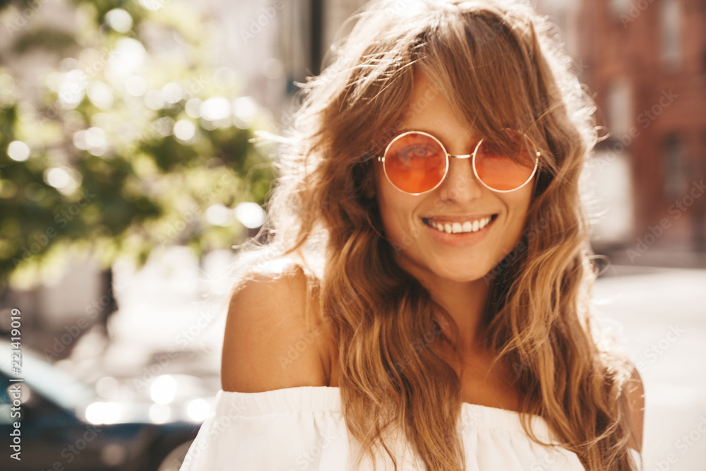 Portrait of beautiful cute blond teenager model with no makeup in summer hipster white dress clothes posing on the street background in sunglasses Portrait of beautiful cute blond teenager model with no makeup in summer hipster white dress clothes posing on the street background in sunglasses