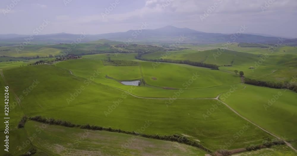 Aerial, beautiful green hills and fields and cypresses landscape in Val d’Orcia in Tuscany, Italy Aerial, beautiful green hills and fields and cypresses landscape in Val d’Orcia in Tuscany, Italy