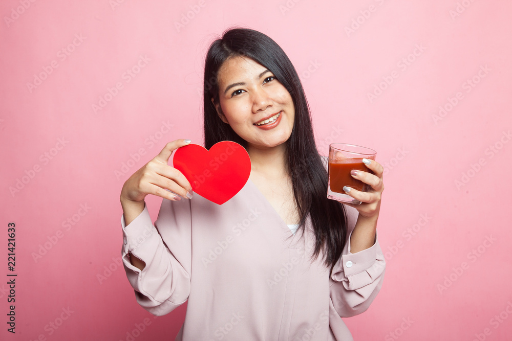 Young Asian woman with tomato juice and red heart. Young Asian woman with tomato juice and red heart.