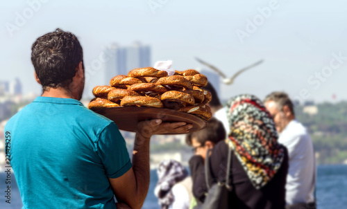 Istanbul, Turkey. A street vendor carries traditional Turkish bagels (Simit) on the Bosphorus embankment. View from the back.