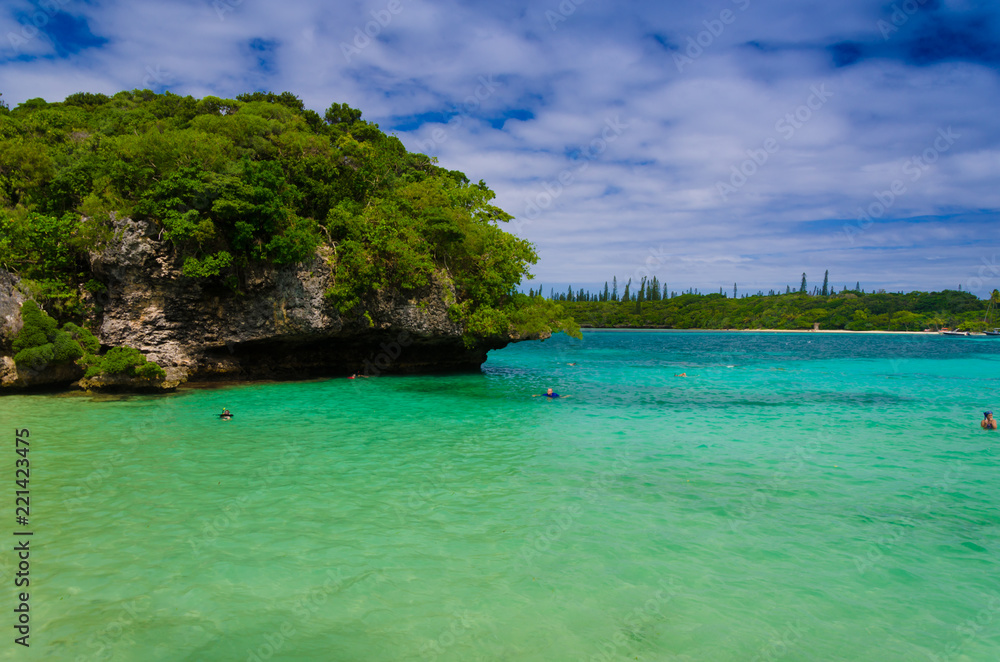 Obraz premium Empty abandoned quiet island with sea green bule water and cloudy sky with forest rock and trees for vacation holiday destination for cruise ship