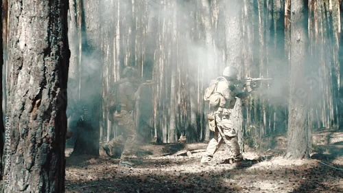 US Army soldiers patrol in a smoky forest photo