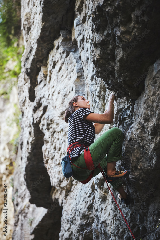 girl rock climber climbing on the cliff
