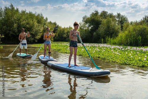 Man and women stand up paddleboarding
