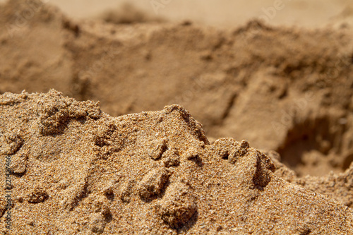 Mountain ranges of sea sand. Reduced model of mountains and rocks from sand. Canyons and cliffs created from sand. The concept of the desert and mountain ranges.