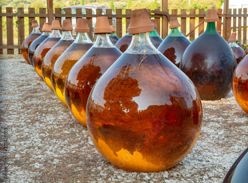 Making of natural sweet dessert muscat liqueur white wine outside in big round glass antique demijohn bottles in Frontignan, south of France photo