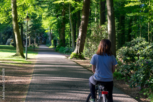 Wallpaper Mural Jovem montada em bicicleta num passeio no meio de um parque Torontodigital.ca