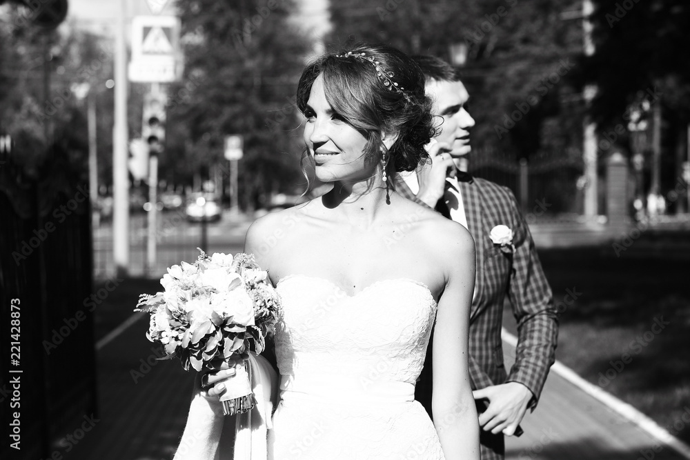 Naklejka premium Newlyweds groom and bride walking in autumn park