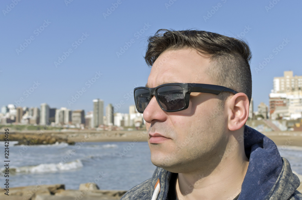 young man walking on the beach on a sunny day young man walking on the beach on a sunny day