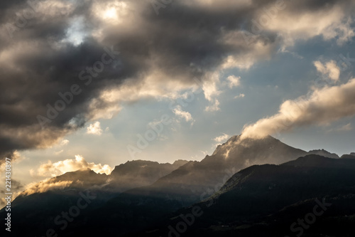 Cime di montagne scure con nuvole all'alba