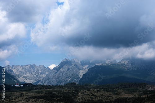 The landscape view of the High Tatra Mountains range. Storm clouds hide the peaks of the mountains. Small town at the foot of the mountains. Slovakia