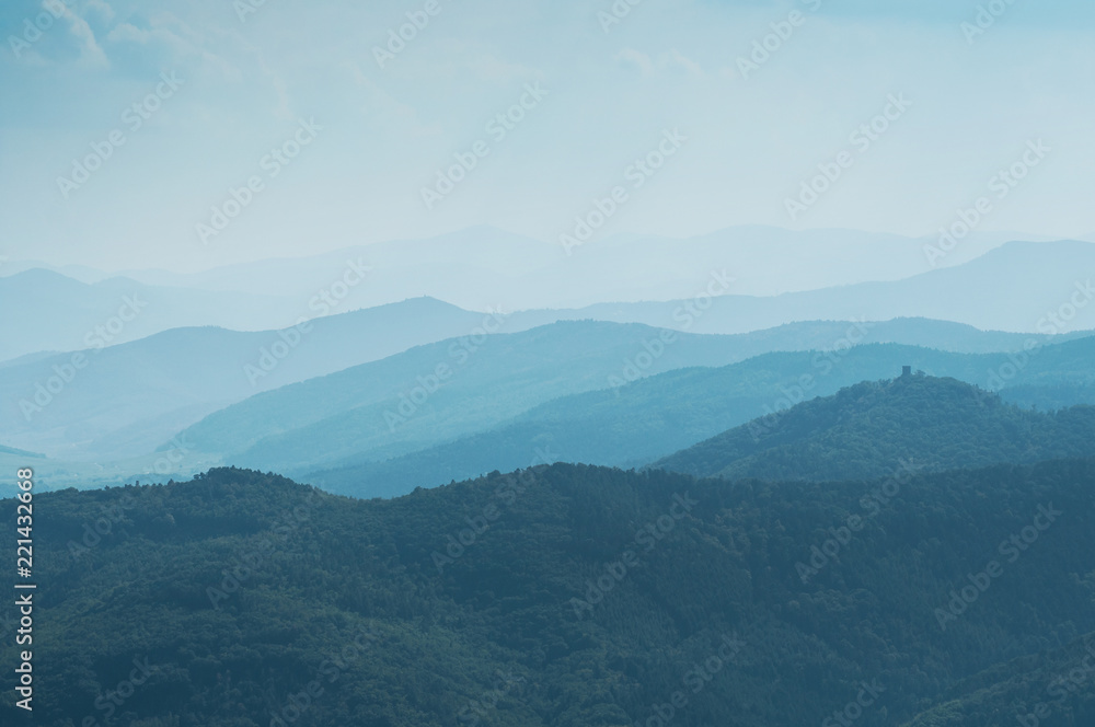 Abstract blue Landscape with Silhouettes of Misty Mountains and Forest. Multilevel Mountain Range in the Background and a Dense Forest in the Foreground