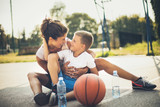 Family team. Mother and son at basketball playground.