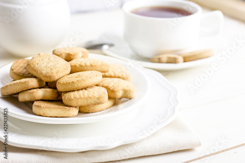 Sugar shortbread cookies in white plate with cup of tea