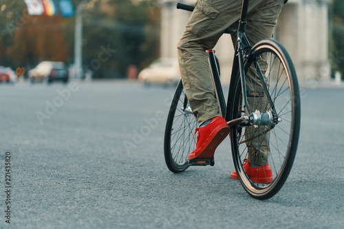 Closeup of casual man legs riding classic bike on city road © arthurhidden