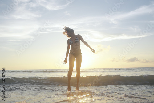 girl is having fun and jumping on beach freedom / concept freedom and summer beach, sporty graceful girl is jumping and having fun beach