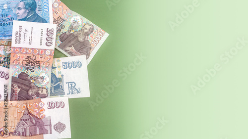 Pot of Icelandic krona banknotes laying on green carpet as a background