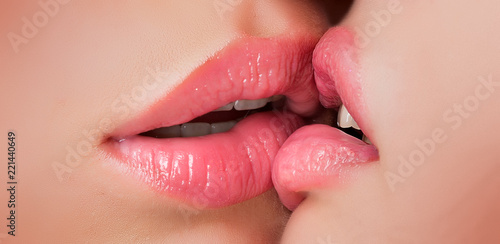 Kiss lesson. Two women friends kissing. Two beautiful sexy lesbians in love. Closeup of women mouths kissing. Passionate kissing. Sexy plump full lips. Lipstick and lipgloss. photo