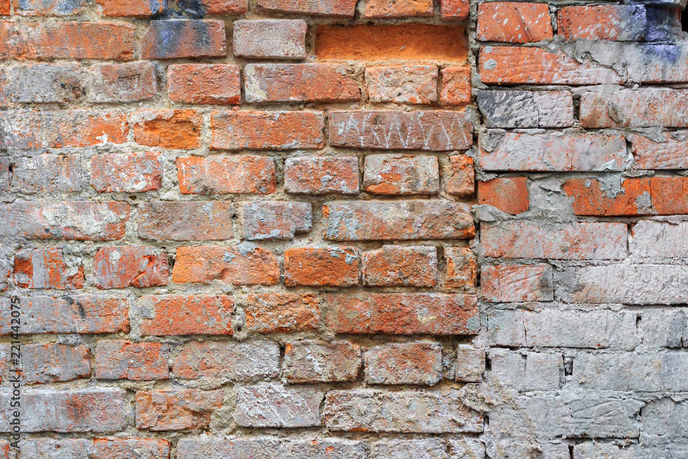 Fototapeta premium Weathered vintage red brick wall texture with paint stains. Abstract brick wall background
