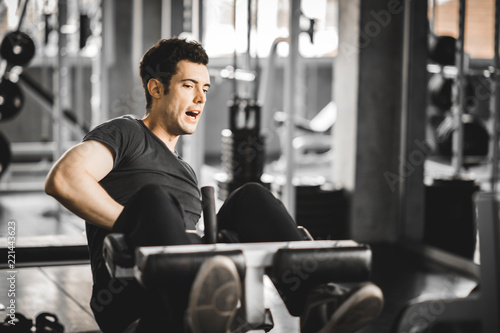 Fit handsome caucasian man sit up on machine in sportswear. Young man sit up exercise to strengthen their core abdominal muscles at fitness training in gym. Healthy, Sports, Lifestyle, Fitness concept