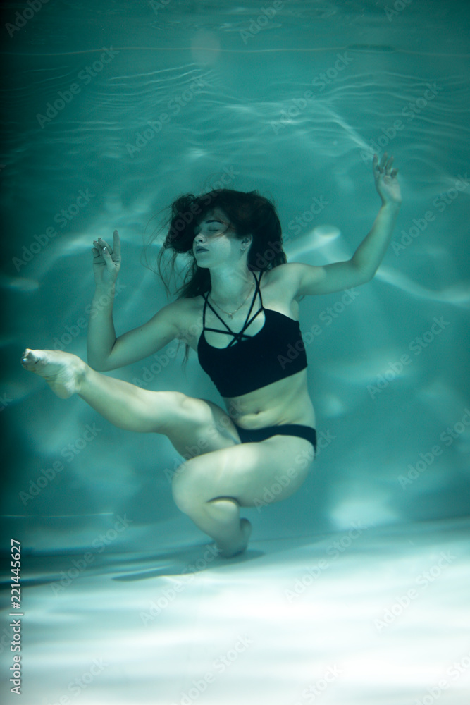 Woman under the water in a black clothes.