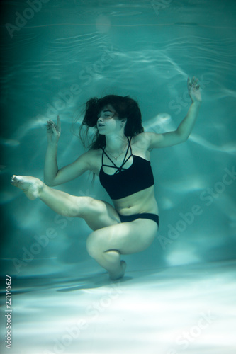 Woman under the water in a black clothes.