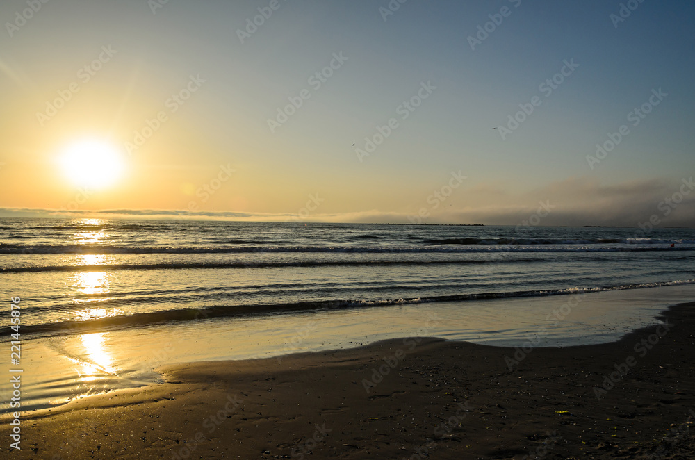 Beach of Black Sea from Mamaia, Romania at sunrise , warm sunshine atmosphere