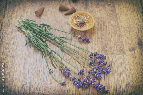 Fototapeta Naklejka Na Ścianę i Meble -  Lavender flowers and incense aroma cones on a wooden table. Vintage style.