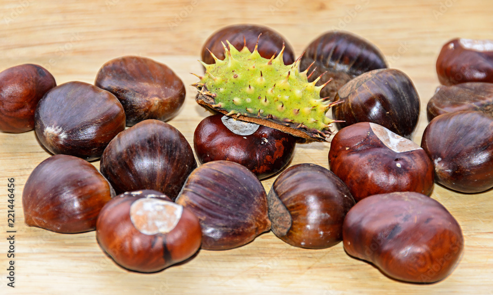 Edible brown chestnuts close up, wooden background Edible brown chestnuts close up, wooden background