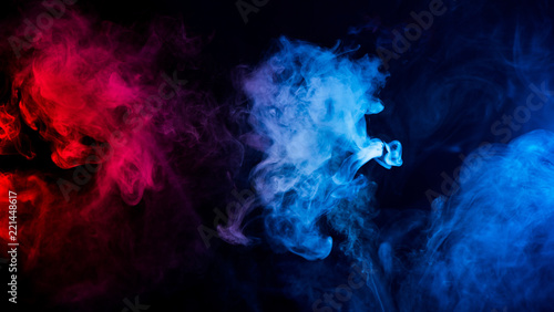 abstract shapes of mixed colors of blue and red smoke at dark background