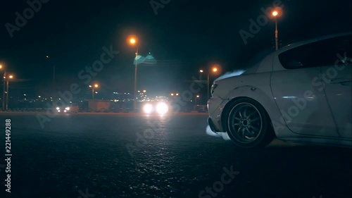 White sports car in drift smoke with tires photo