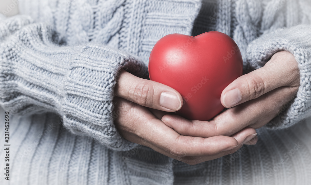 woman in winter dress holding heart woman in winter dress holding heart