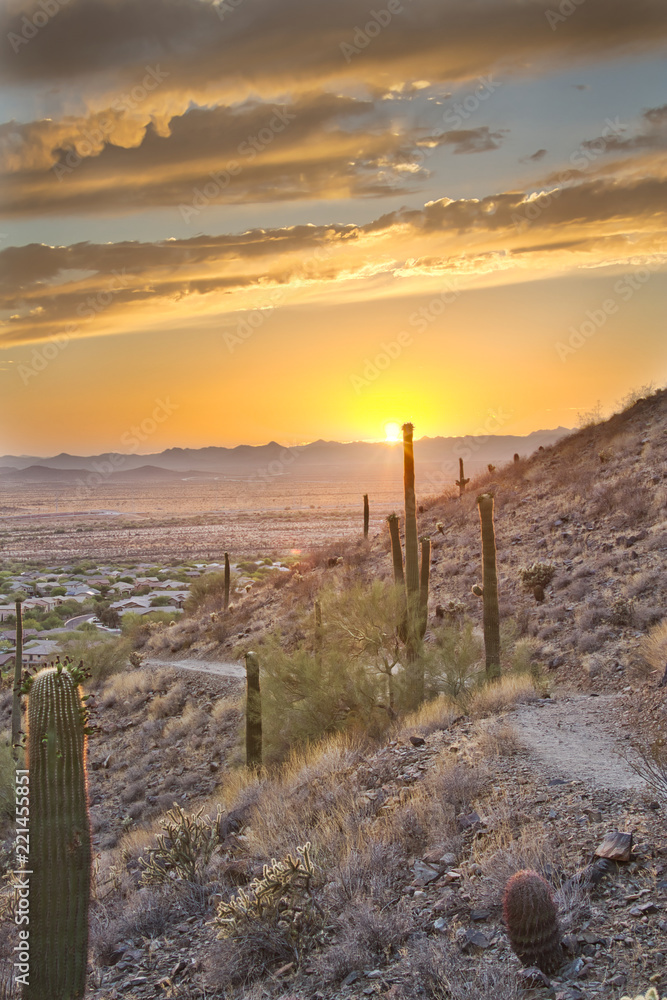 A hiking trail on the side of a mountain heading into an Arizona sunset.