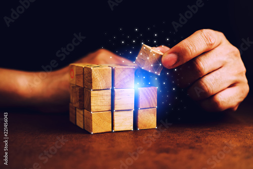 Fotografia business man try to build wood block on wooden table and blur background busines