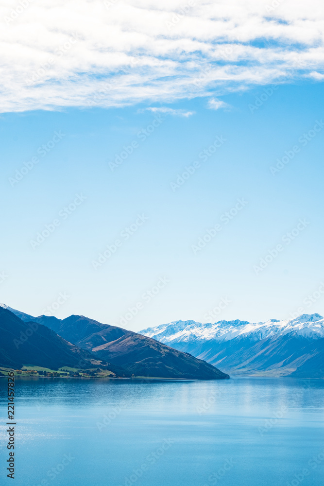 Stunning beautiful view beside lake Wanaka with alps mountain. Noon scenery with some cloudy and blue sky.
