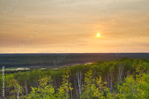 The sun setting over the forest of Prince Albert National Park.