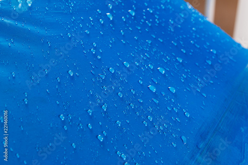 Rain water droplets on  blue waterproof fabric  background