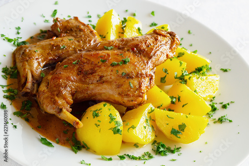 stewed in white wine with herbs and spices marinated rabbit legs on potato sprinkled with parsley
