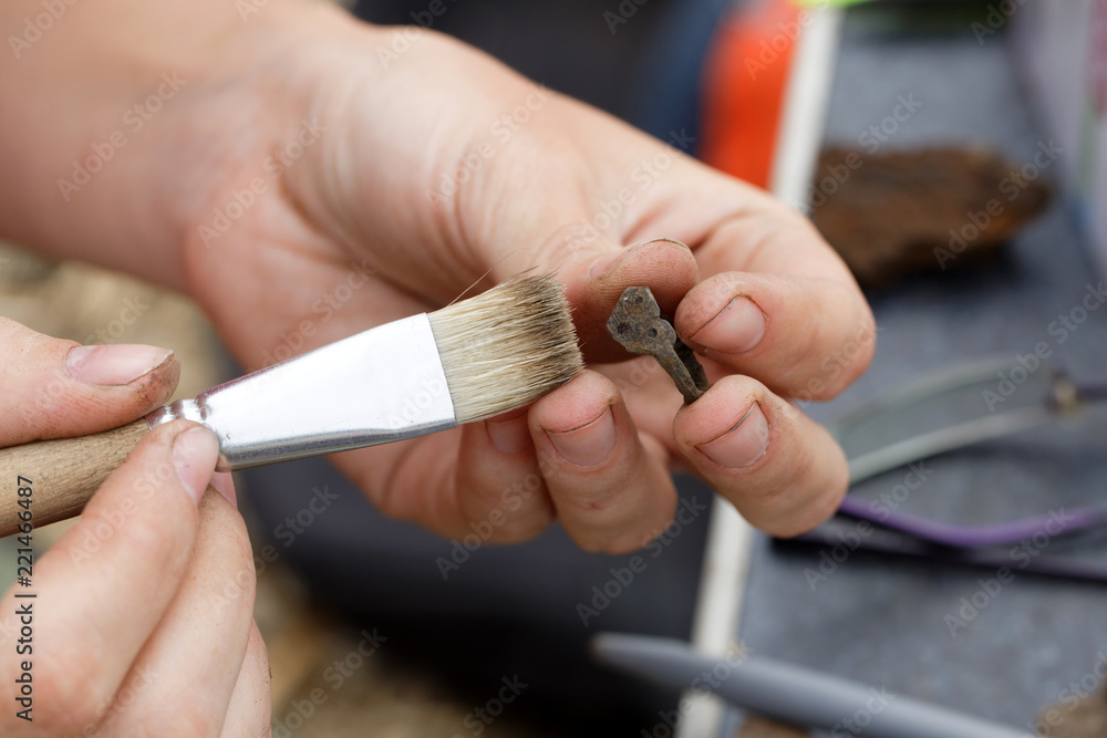 An archaeologist clears the medieval primitive jewelry