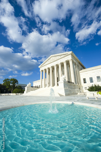 Neoclassical columned entrance portico to the US Supreme Court building in Washington DC with fountain in the foreground.