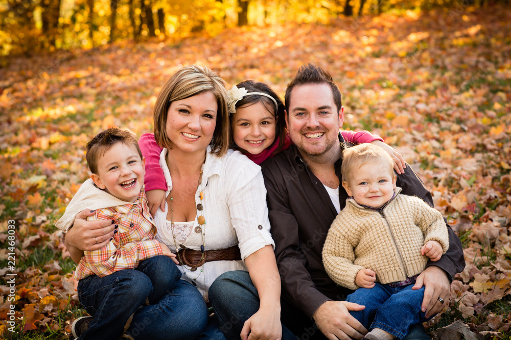 Happy Family Sitting Together in Autumn Park Happy Family Sitting Together in Autumn Park