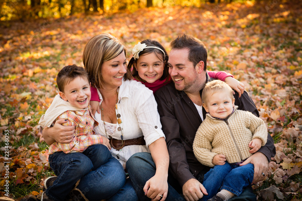 Happy Family Sitting Together in Autumn Park Happy Family Sitting Together in Autumn Park